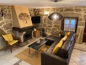 a living room with a couch and a stone fireplace at Casa Rualeira in Combarro