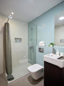 a bathroom with a toilet and a shower and a sink at Casas Barulho Apartment Old Town in Albufeira