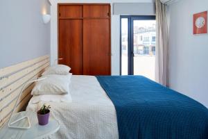 1 dormitorio con 1 cama con manta azul y blanca en Casas Barulho Apartment Old Town, en Albufeira