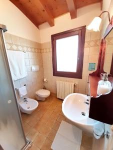 uma casa de banho com um lavatório e um WC em Agriturismo Le Cipressine em Meolo