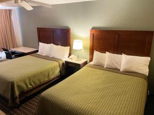 a hotel room with two beds and two lamps at Great Western Inn & Suites in Carlsbad