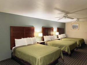 a hotel room with two beds and two lamps at Great Western Inn & Suites in Carlsbad