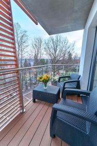 a balcony with chairs and a vase of flowers at LAGUNA Apartament Polanica Residence 32 in Polanica-Zdrój