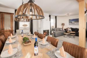 a dining room with a table and a living room at Pistenblick Chalet in Sankt Margarethen im Lungau