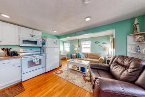 cocina y sala de estar con electrodomésticos blancos y sofá en Hampton Beach Hangout & Nancy's Villa, en Hampton