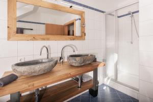 two sinks on a wooden counter in a bathroom at Pistenblick Chalet in Sankt Margarethen im Lungau +8 photos