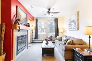 a living room with a couch and a fireplace at Ski-In Ski-Out Modern Mountain Condo in Winter Park