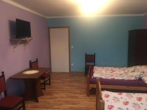 a room with a bed and a table and a room with a table and chairs at Agroturystyka pod świerkami in Giebułtów