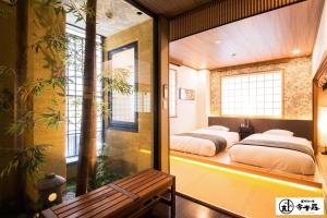 duas camas num quarto com uma janela e um banco em Dotonbori no Yado Konjakuso - Vacation STAY 24305v em Osaka