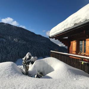 una pila de nieve frente a una cabaña en La marmotte qui papote en Le Grand-Bornand