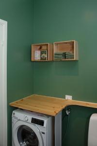 a washing machine with a wooden counter on top of it at Úti í Kina in Tórshavn