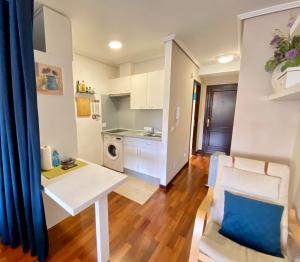 ein Wohnzimmer mit einem weißen Tisch und eine Küche in der Unterkunft FLORIDA 125 in Vigo
