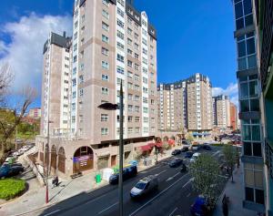 un edificio alto con auto parcheggiate in città di FLORIDA 125 a Vigo