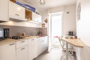 a kitchen with white cabinets and a wooden counter top at Waikiki in Biarritz