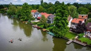an aerial view of a river with houses and people in a boat at Ciprus Lak in Szarvas