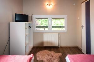 a bedroom with a white refrigerator and a window at Ciprus Lak in Szarvas