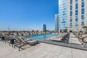 uma piscina com espreguiçadeiras e um edifício em Omni Oklahoma City Hotel em Oklahoma City