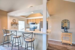 a kitchen with three bar stools at a counter at Resort Home with Hot Tub on Lake of the Ozarks! in Osage Beach