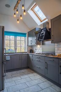a kitchen with gray cabinets and a skylight at Highland Annexe, Munlochy, The Black Isle in Munlochy