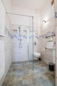 a bathroom with a glass shower and a toilet at Green - Apartamenty Kleparskie in Kraków