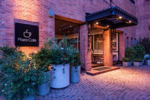 a brick building with pots of plants in front of a store at Estelar Apartamentos Bogotá - La Fontana in Bogotá