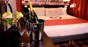 two wine bottles in a bucket next to a bed at Hotel Victoria Lyon Perrache Confluence in Lyon