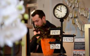 a man is looking at a clock on a table at Hotel Victoria Lyon Perrache Confluence in Lyon
