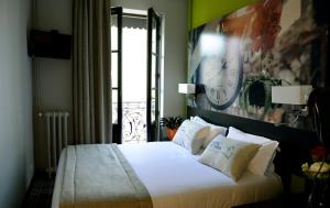 a bedroom with a bed with a clock on the wall at Hotel Victoria Lyon Perrache Confluence in Lyon