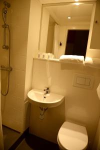 a bathroom with a sink and a toilet and a mirror at Hotel Victoria Lyon Perrache Confluence in Lyon