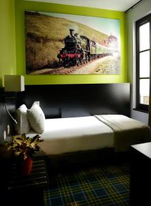 a bedroom with a painting of a train on the wall at Hotel Victoria Lyon Perrache Confluence in Lyon