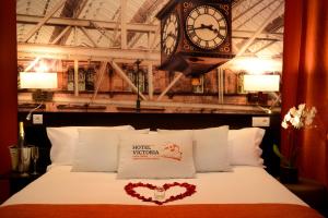 a bedroom with a bed with a clock on the wall at Hotel Victoria Lyon Perrache Confluence in Lyon