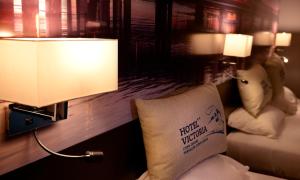 a hotel room with a pillow on a bed with a lamp at Hotel Victoria Lyon Perrache Confluence in Lyon