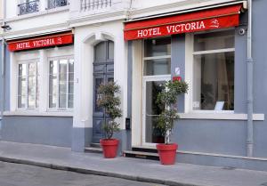 a hotel window with two potted plants in front of it at Hotel Victoria Lyon Perrache Confluence in Lyon