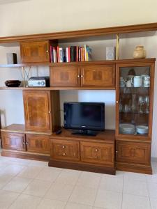 a large wooden entertainment center with a television on it at Casa Ameria in Cecina