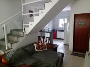 a living room with a bed and a staircase at Lindo sobrado a 100 m praia do Aruan. in Caraguatatuba
