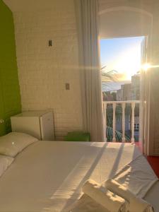 a bedroom with a bed with a view of a balcony at Pousada Nossa Natal in Natal