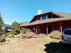 ein Haus mit einem davor geparkten Auto in der Unterkunft Casa Rincón Radales in San Martín de los Andes