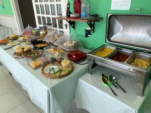 a table with a buffet of food on it at Pousada Nossa Natal in Natal