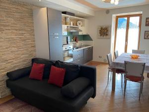 a living room with a black couch and a table at Appartamenti Lucia in Andalo