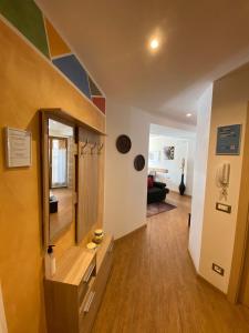 a living room with a large mirror and wooden floors at Appartamenti Lucia in Andalo