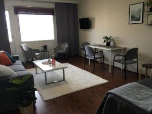 ein Wohnzimmer mit einem Sofa, einem Tisch und Stühlen in der Unterkunft StarHomes City Apartment 4 in Kemi