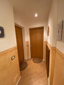 pasillo con 2 puertas y suelo de madera en Appartamenti Lucia, en Andalo