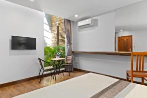 a hotel room with a bed and a table and chairs at Hotel Five.S in Kampot