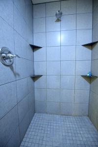 a bathroom with a shower with a tiled floor at Z Loft Extended Stay Hotel in Saint Robert