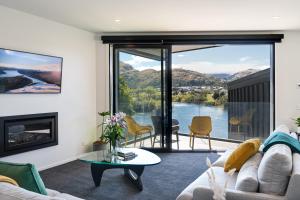 a living room with a couch and a fireplace at Homestead Retreat - 2 Bedroom - Lake View in Queenstown