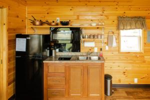a kitchen with a black refrigerator and a sink at Crescent Beach and RV Park in Port Angeles