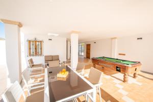 un soggiorno con tavolo da biliardo e sedie di A perfect location villa for holidays with AC and private pool a Port de Pollença
