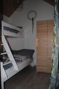 a bedroom with two bunk beds and a closet at Domki nad morzem, Laba Rusinowo koło Jarosławca, in Rusinowo