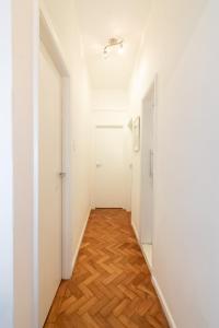 um corredor vazio com paredes brancas e pisos de madeira em 2Qtos a 5 min. da Praia de Ipanema | BT 82/207 no Rio de Janeiro