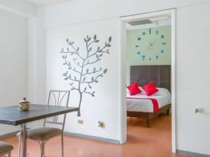 1 dormitorio con 1 cama y reloj en la pared en Hotel Allende 104 en Chihuahua
